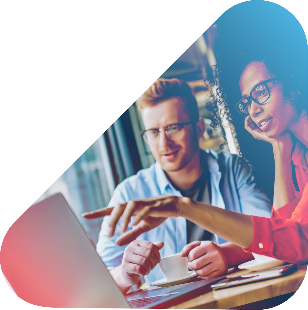 women pointing to laptop screen with man sitting next to her