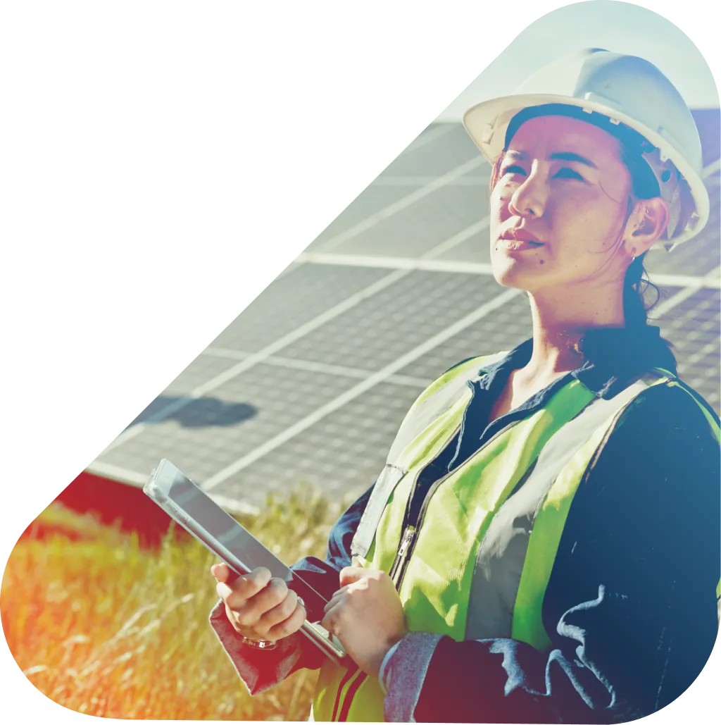 Woman standing in front of a solar farm panel using a tablet